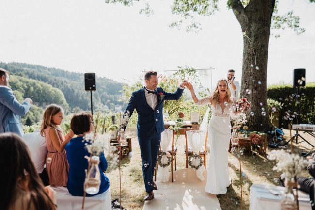 Hochzeit auf dem Weingut Nägelsförst bei Baden-Baden fotografiert von Lisa Un Andi Photography. Braut im Brautkleid von der Bridalboutique Baden-Baden. Freie Trauung mit Blick über die Weinreben.