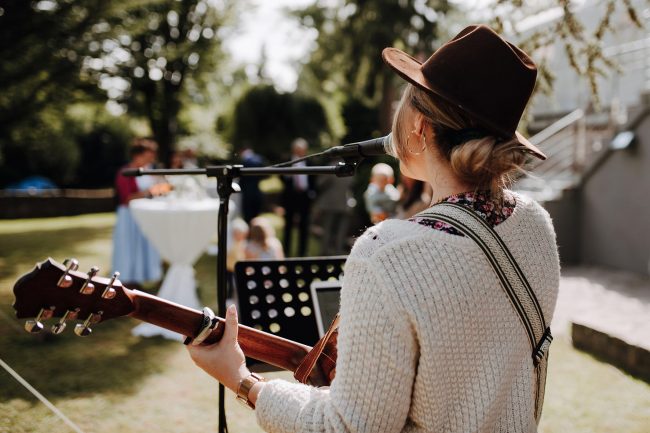 Herzstimme Jule Sophie, Hochzeitssängerin mit Gitarre und Mitglied der Blackforest-Wedding-Crew