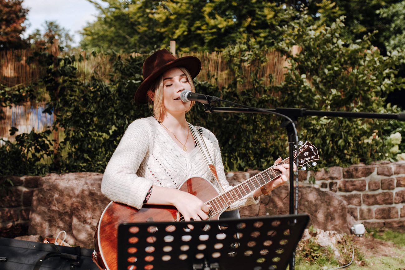 Herzstimme Jule Sophie, Hochzeitssängerin mit Gitarre und Mitglied der Blackforest-Wedding-Crew